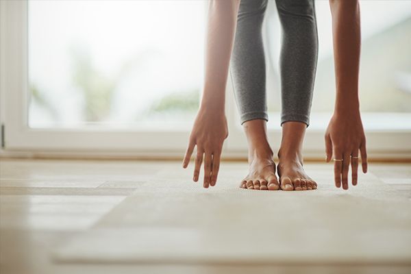 a woman is doing a yoga pose on a mat in front of a window .