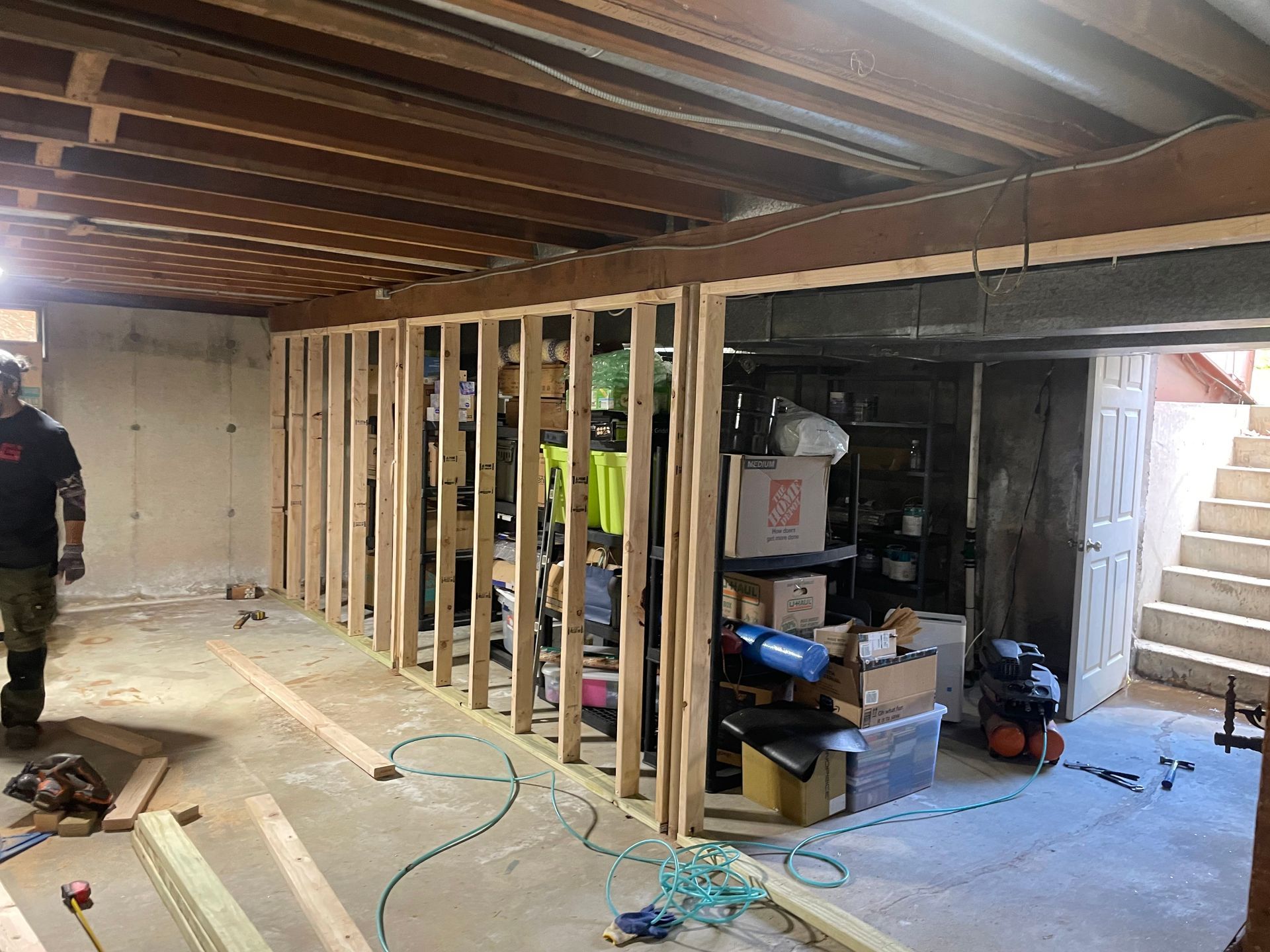 A man is standing in a basement under construction.