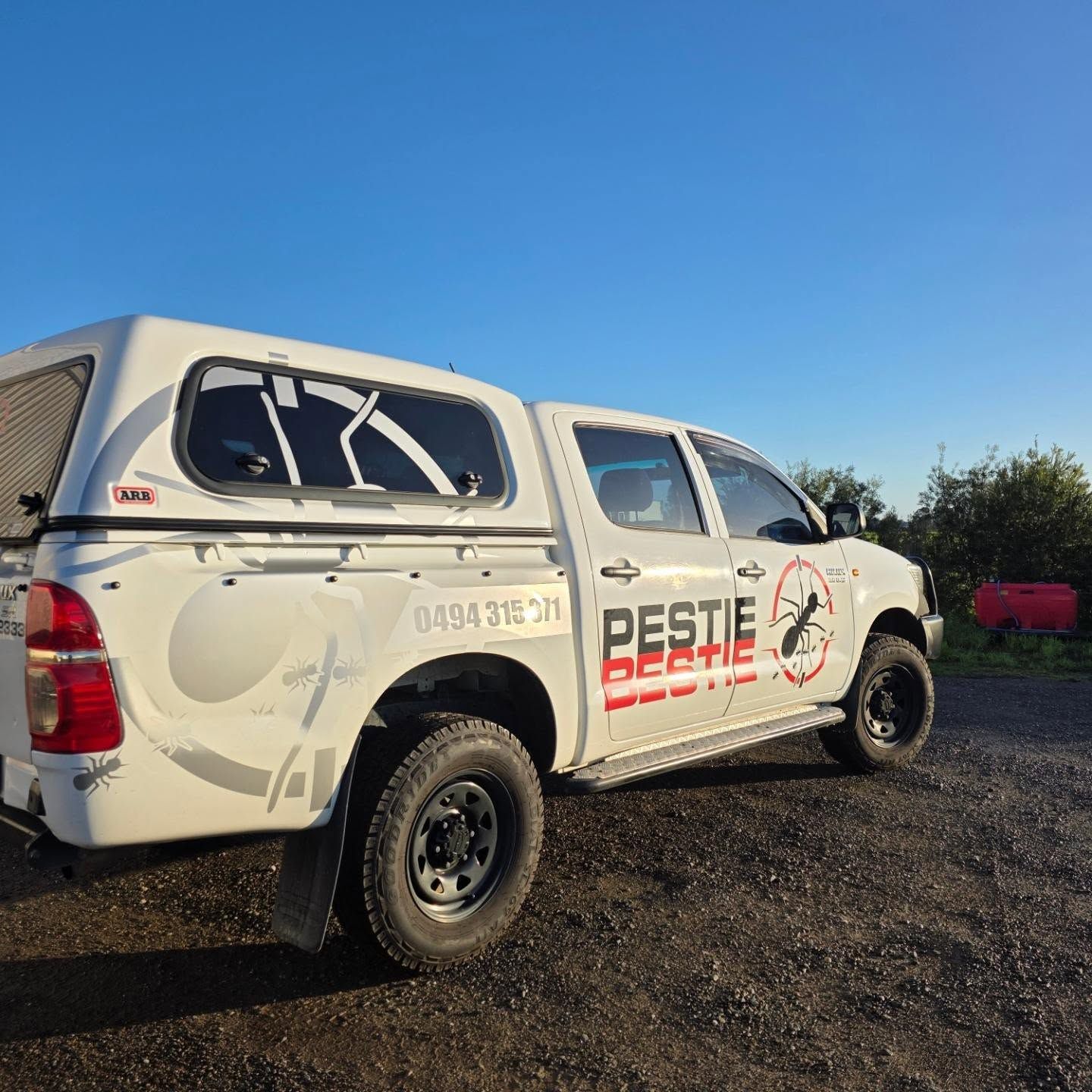 White Pest Control Pickup Truck Parked on Gravel Under a Clear Blue Sky — Pestie Bestie Pest Control In Benalla, VIC