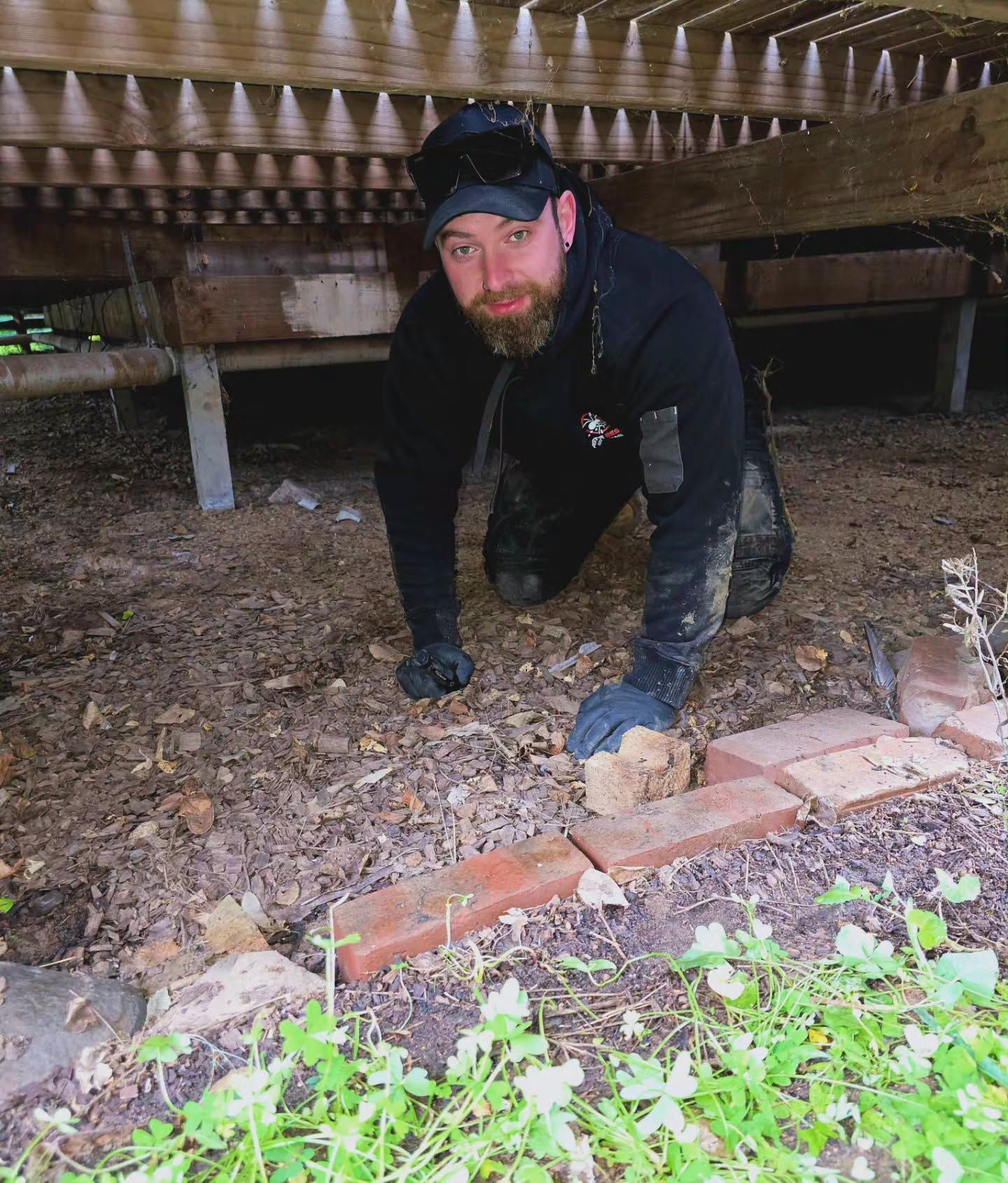 Pest Exterminator Inspecting Under a Wooden Deck — Pestie Bestie Pest Control In Shepparton, VIC