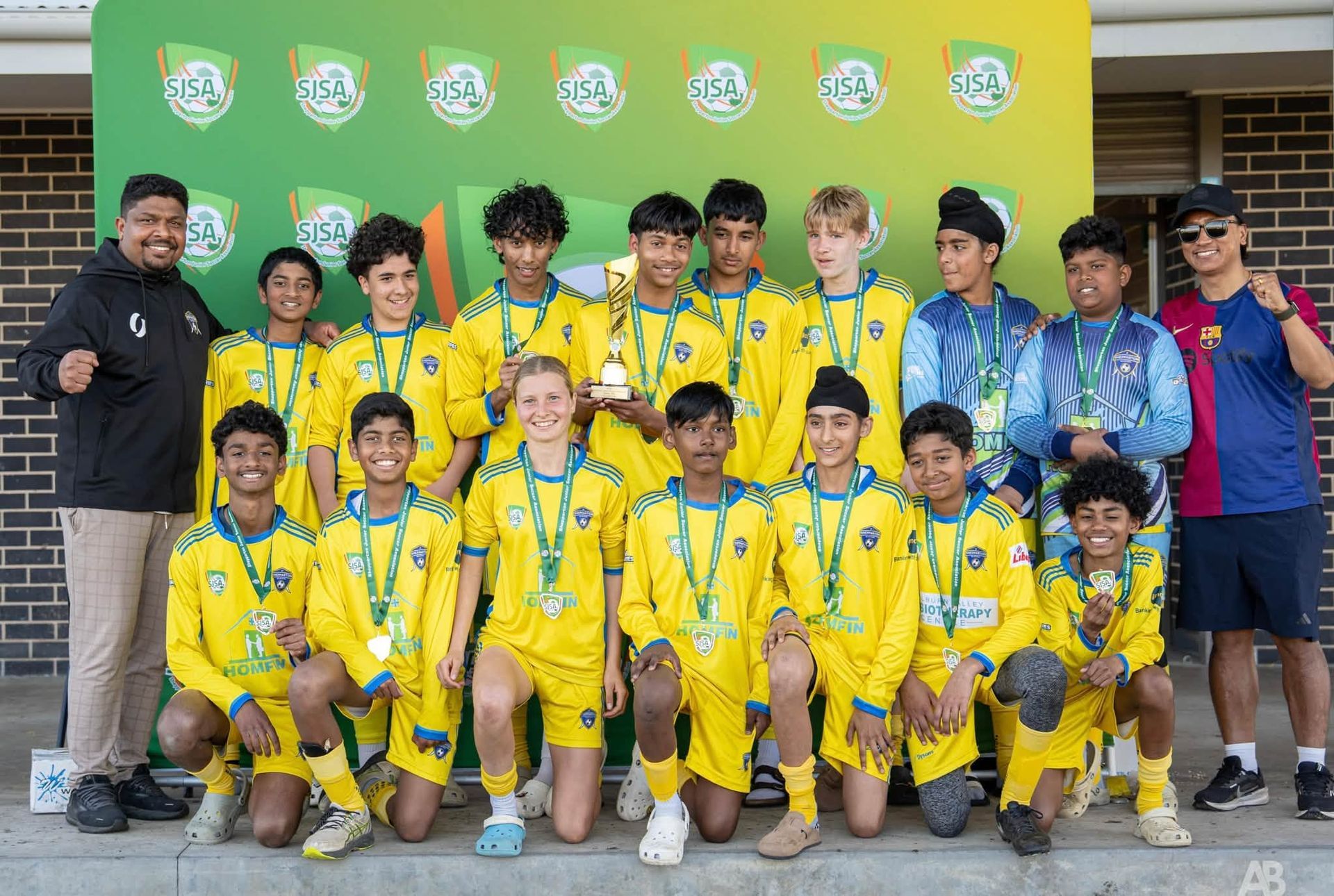 Soccer Team Group Photo in Yellow and Green Uniforms Posing With Coaches — Pestie Bestie Pest Control In Shepparton, VIC