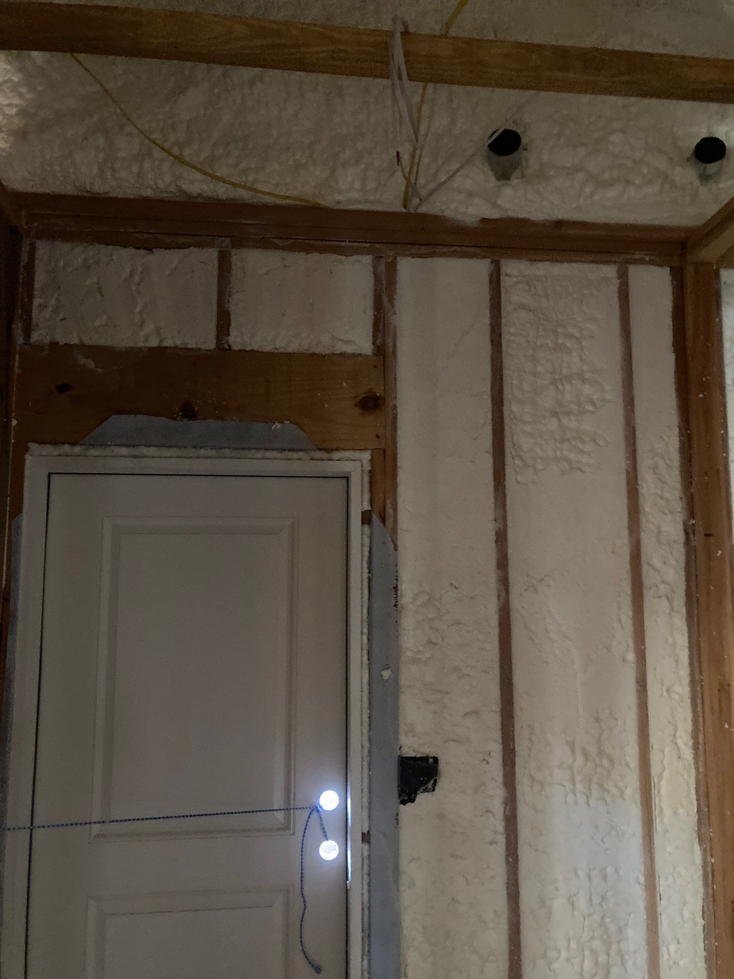 A door is being built into a wall with foam insulation.