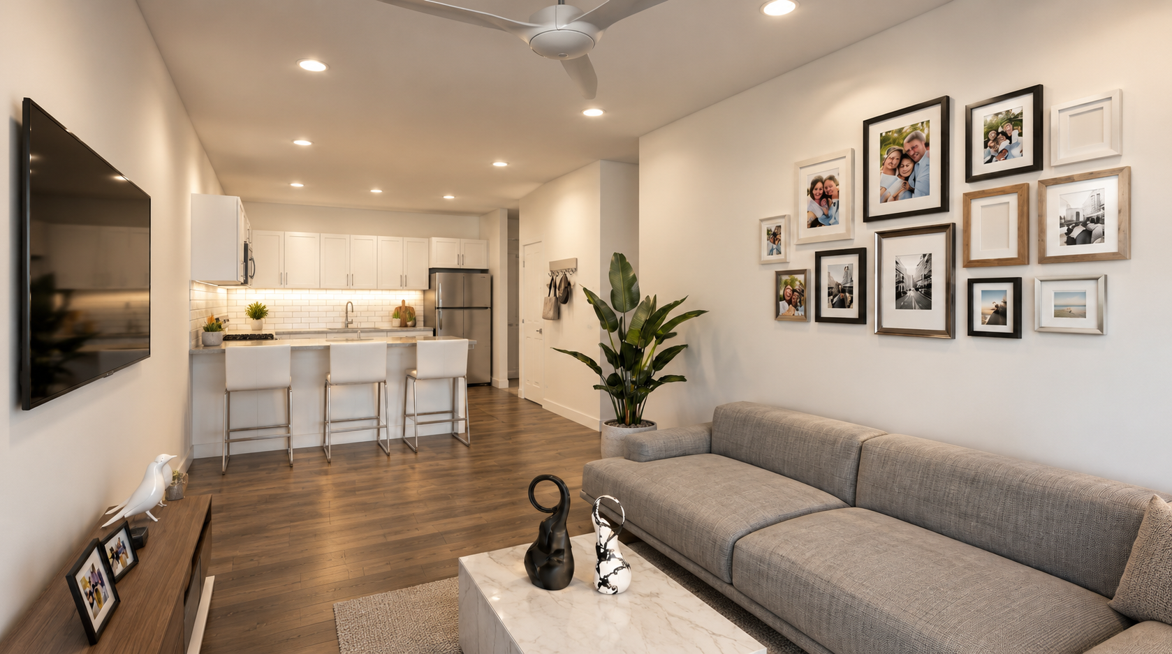 Artist's Rendering - Bright modern living room with gray sofa, gallery wall, and open kitchen in the background