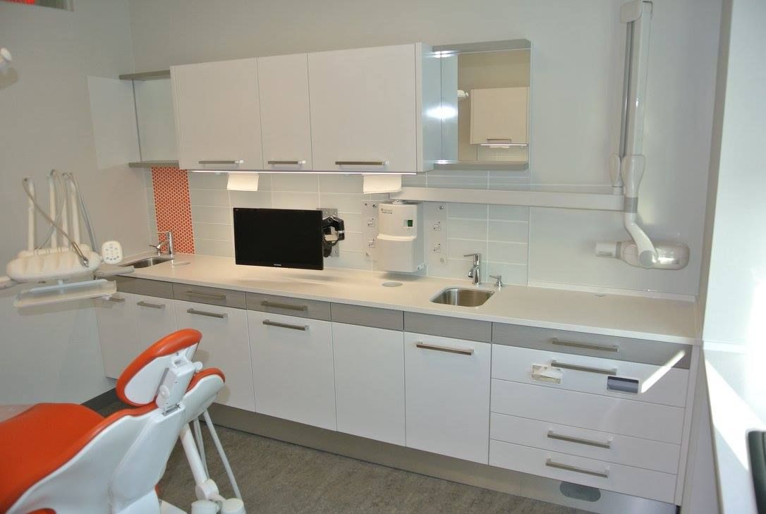 Un cabinet dentaire avec une chaise dentaire et un lavabo