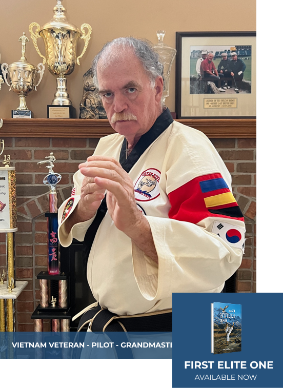 Man in martial arts uniform, poised in fighting stance. Awards and photo frame in background.