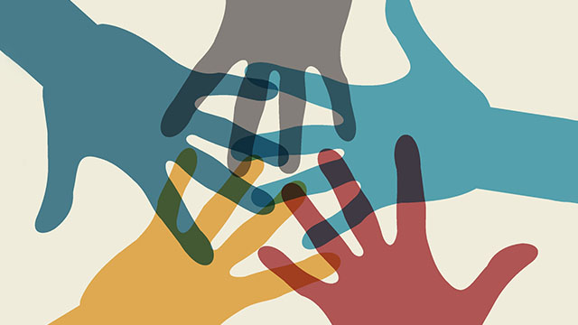 A group of hands are stacked on top of each other