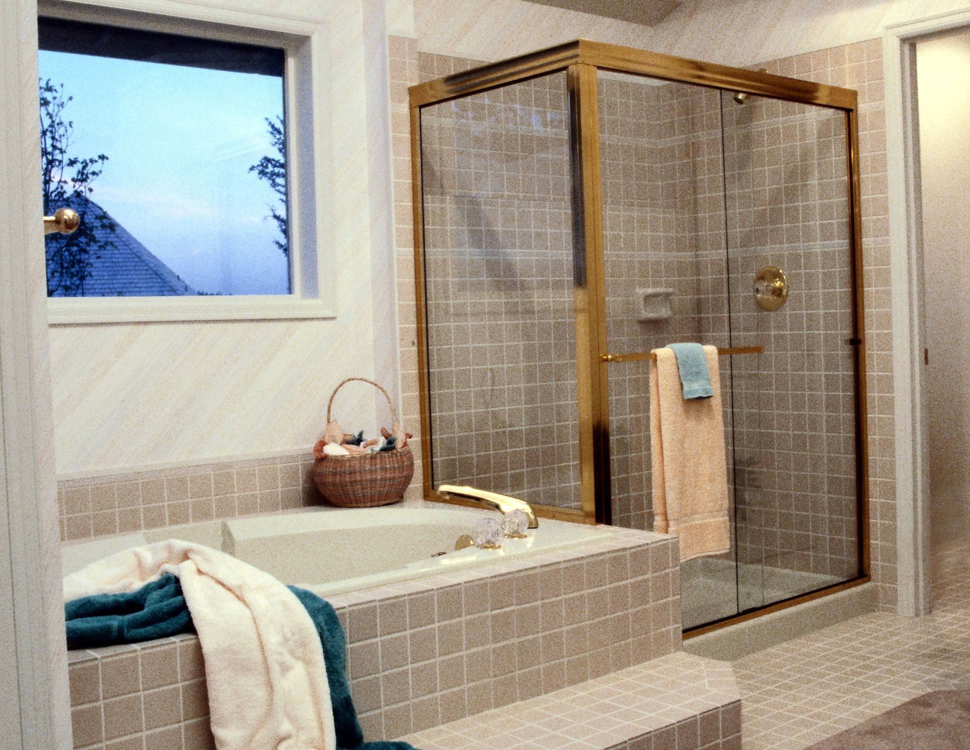 A bathroom with a tub a shower and a window.