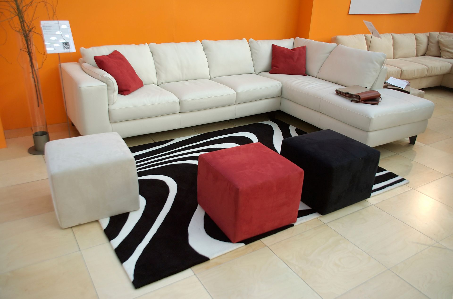 A living room with a sectional couch and ottomans.
