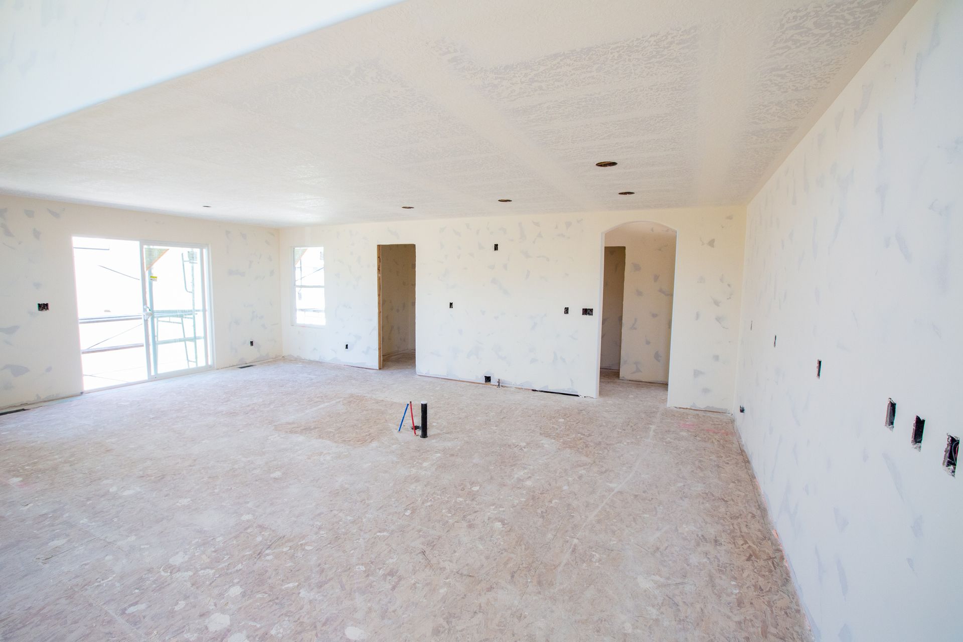 A large empty room with a carpeted floor and white walls.