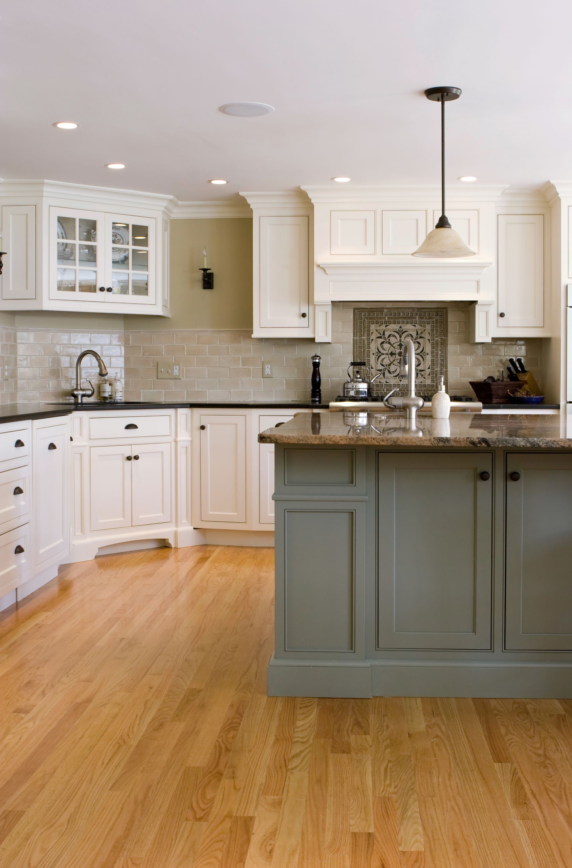 A kitchen with white cabinets and a large island.