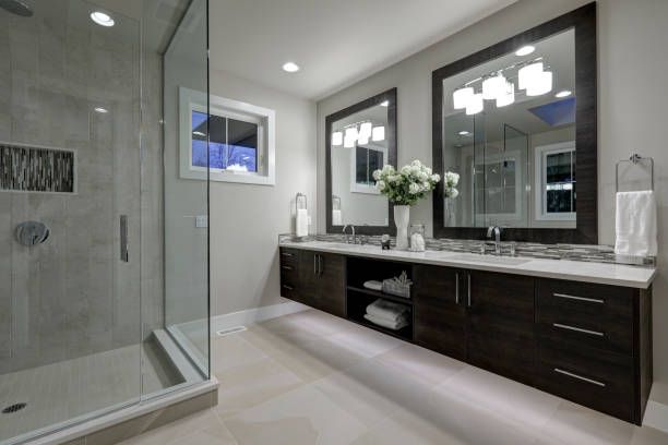 A bathroom with two sinks and a walk in shower.
