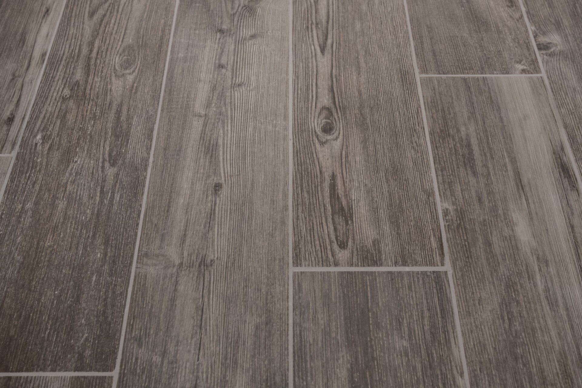 A close-up of a tile floor that looks like wood. A close-up of a tile floor that looks like wood.