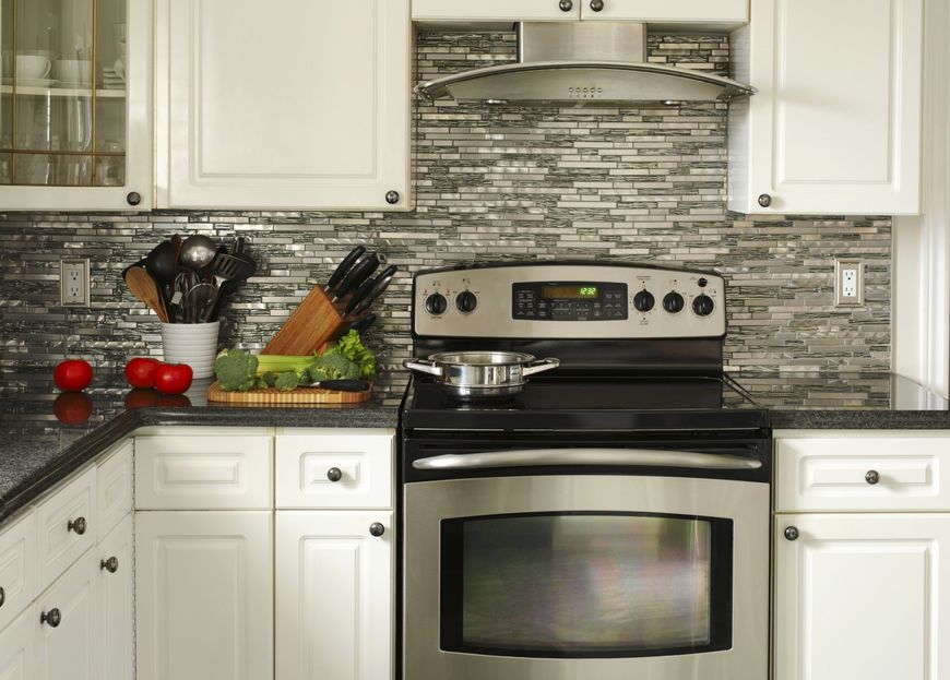 A kitchen with stainless steel appliances and white cabinets.