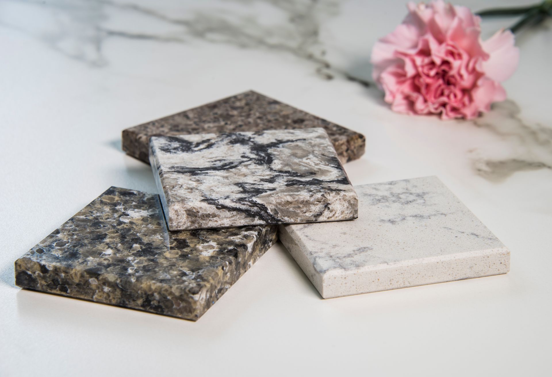 A stack of marble coasters with a pink flower.