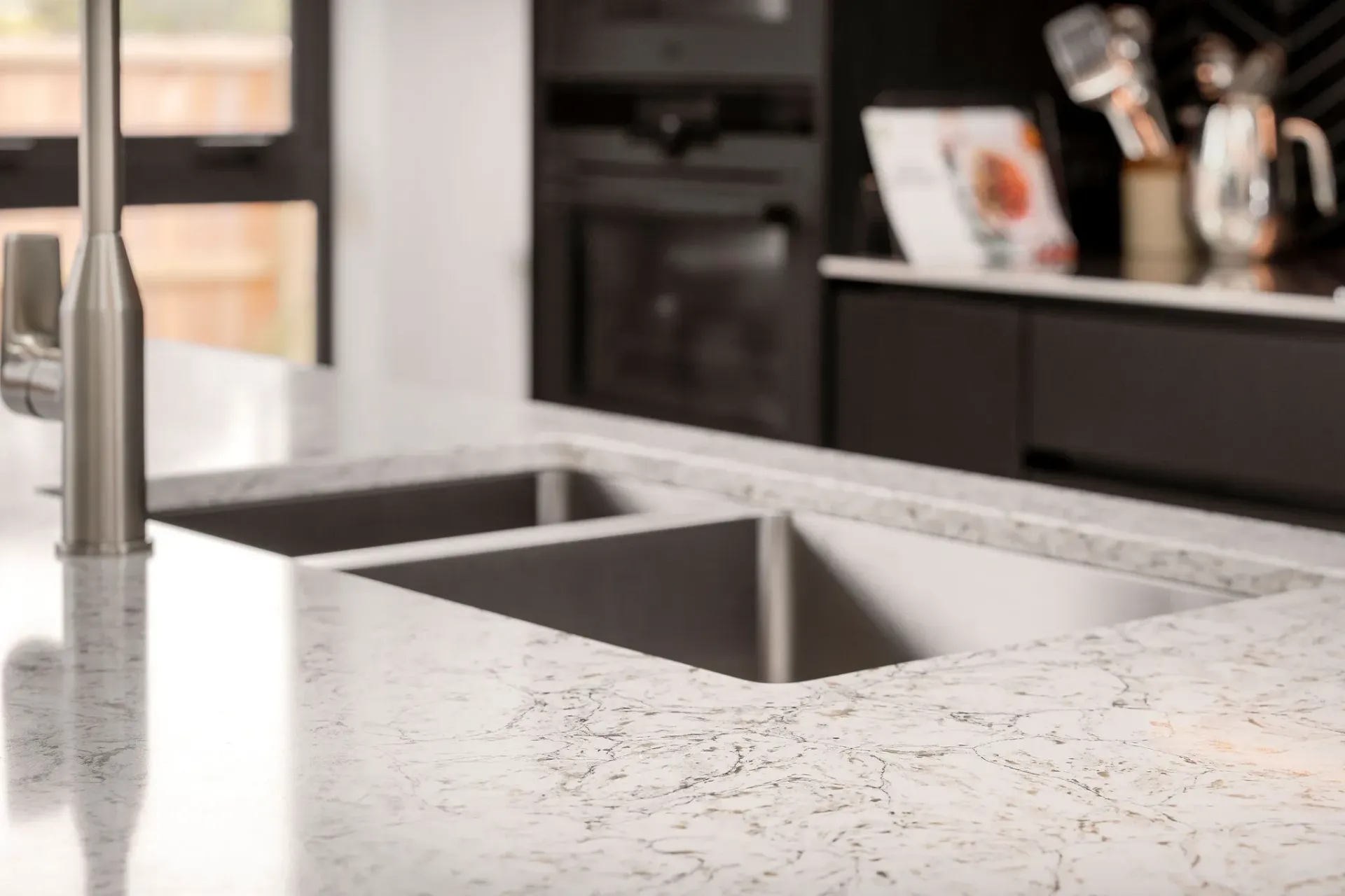 A kitchen with two sinks and a faucet.