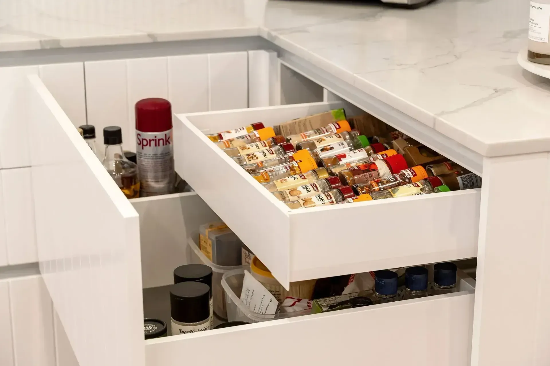 A kitchen drawer filled with lots of spices and condiments.
