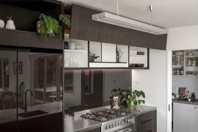 A kitchen with stainless steel appliances and black cabinets