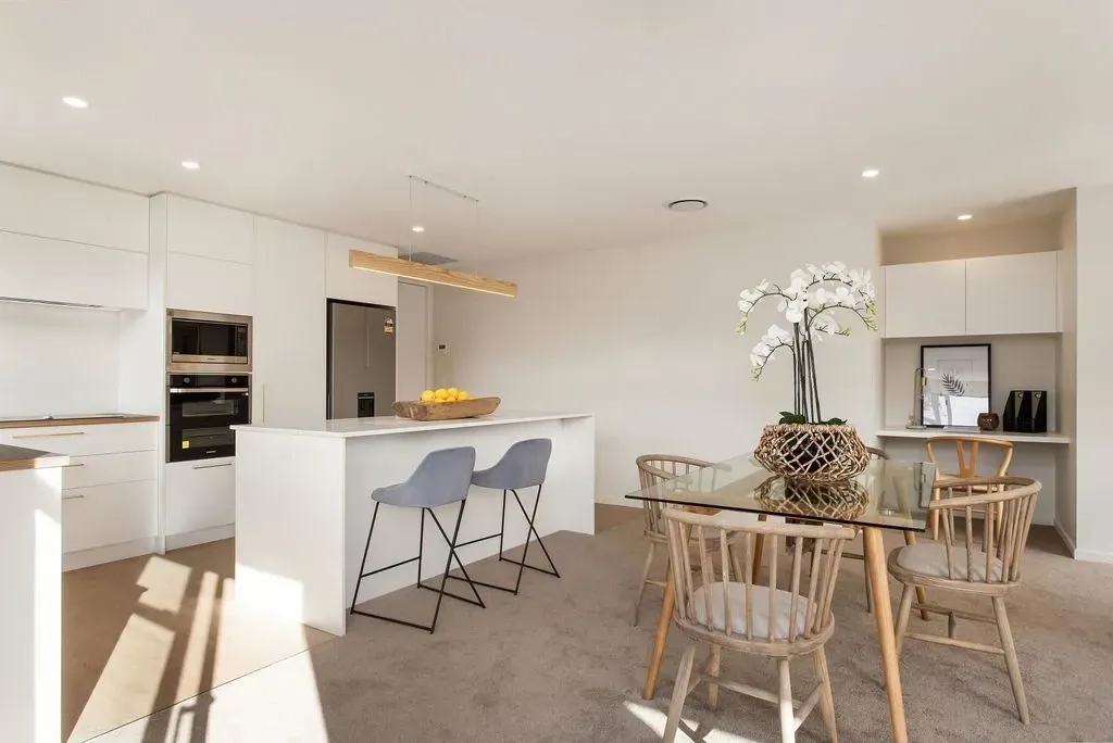 A kitchen and dining room in a house with a table and chairs.