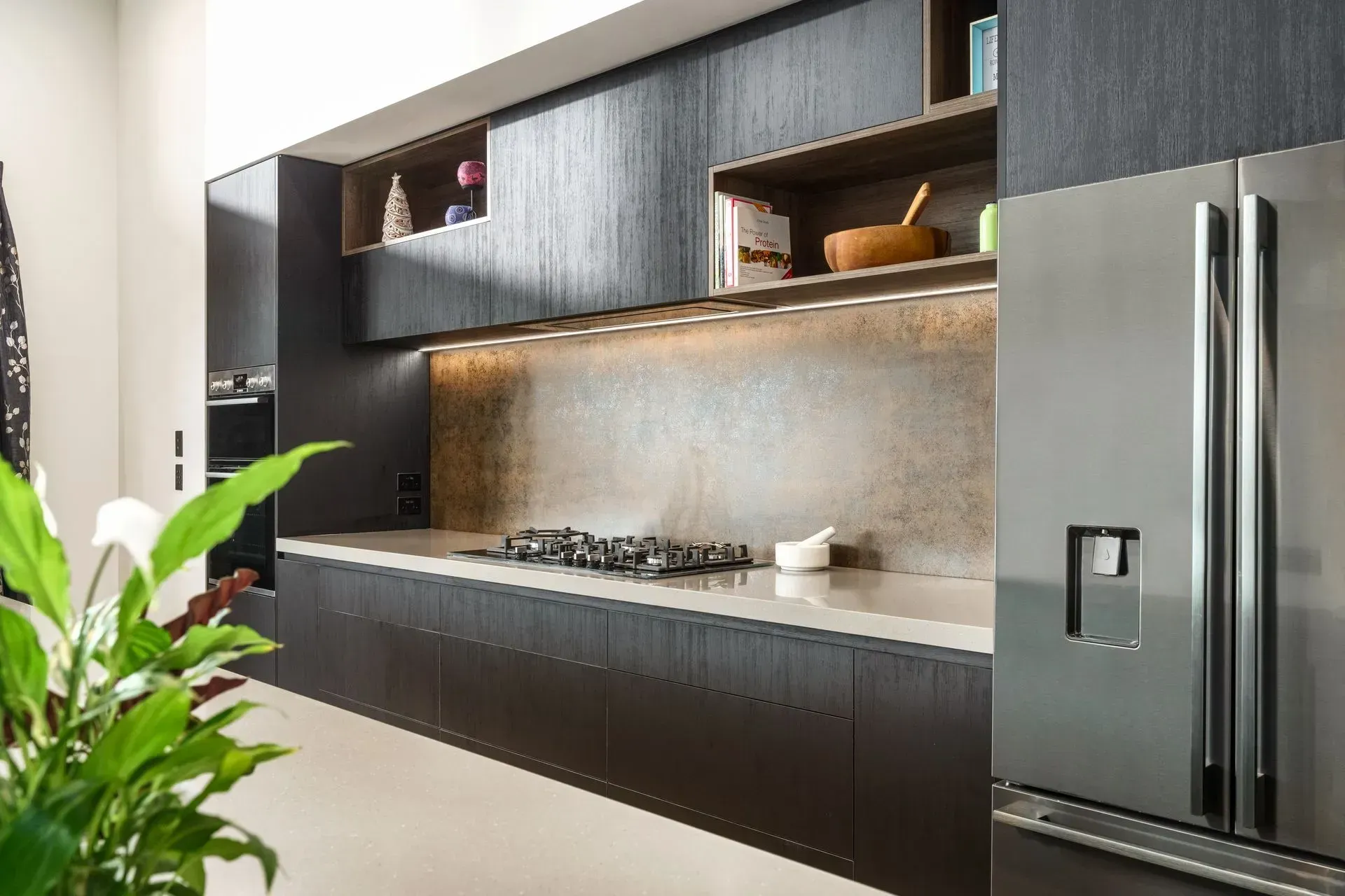 A kitchen with stainless steel appliances and a stove top oven.