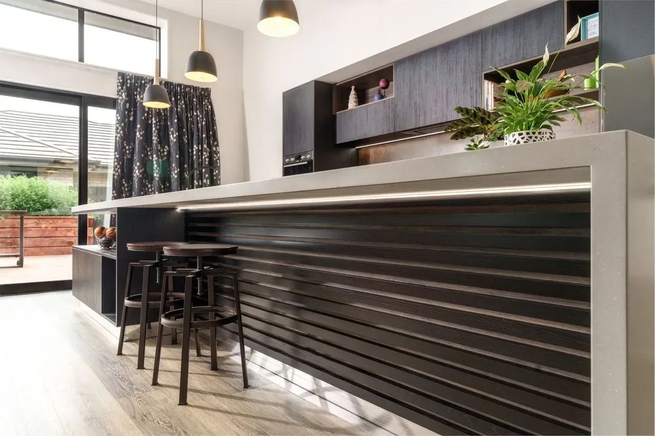 A kitchen with a bar and stools in it