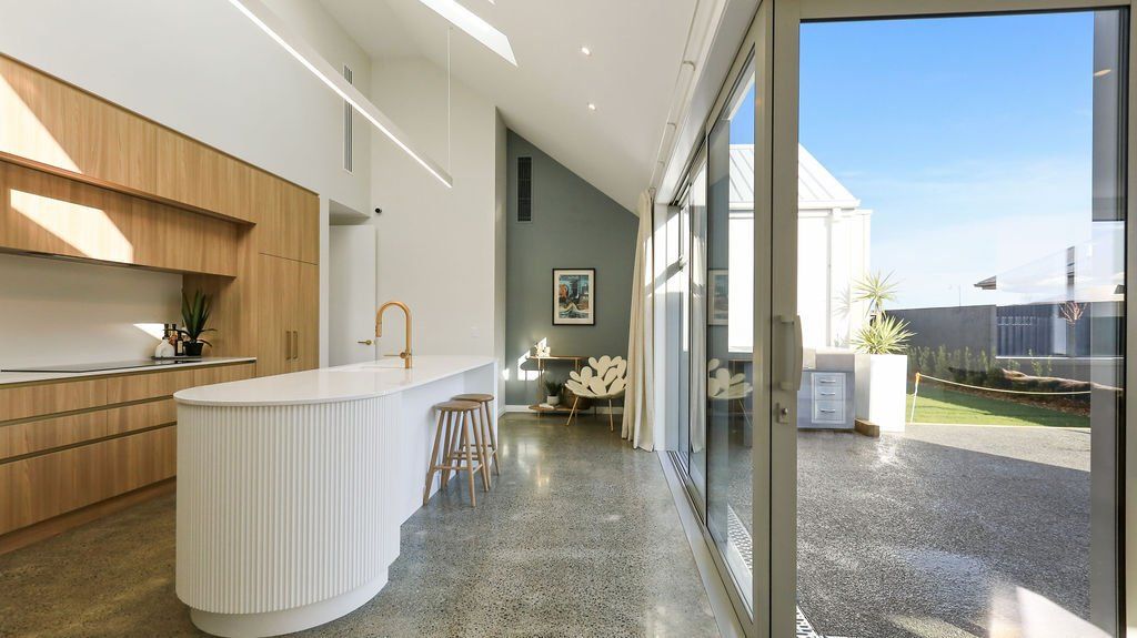 A kitchen with a large island and sliding glass doors leading to a backyard.