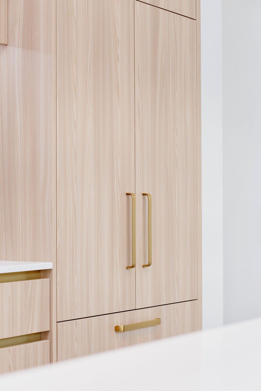 A kitchen with wooden cabinets and brass handles