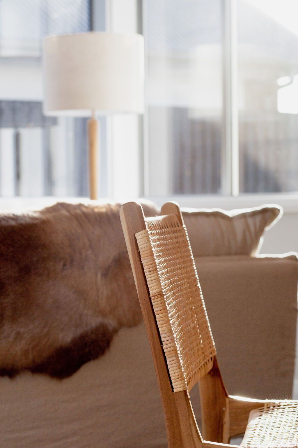 A wicker chair in a living room next to a couch