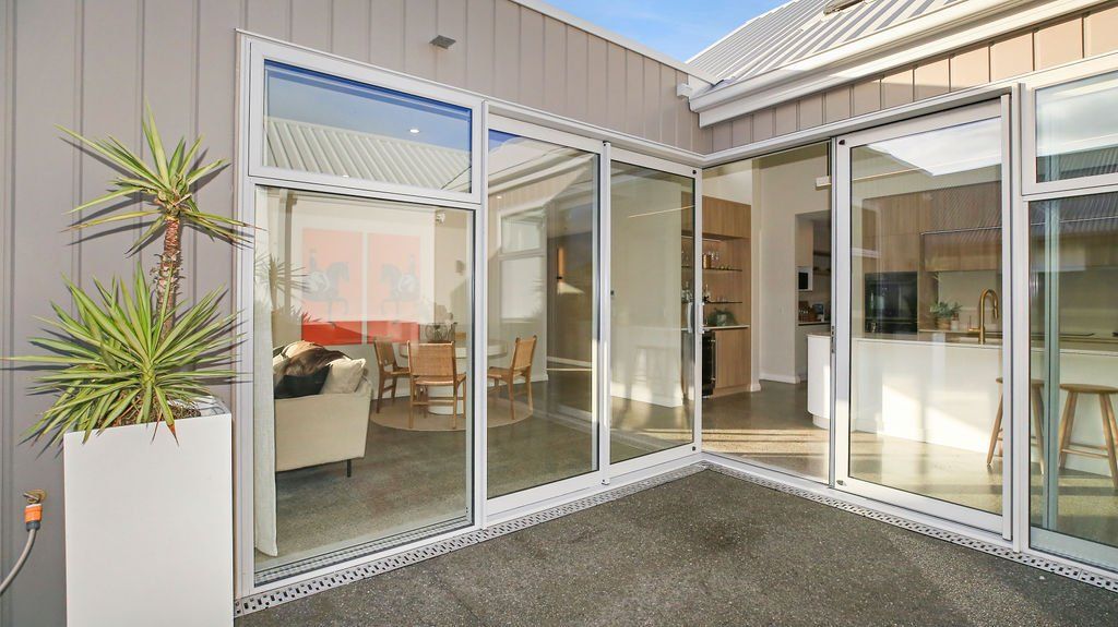 A house with a lot of windows and a patio in the middle of it.