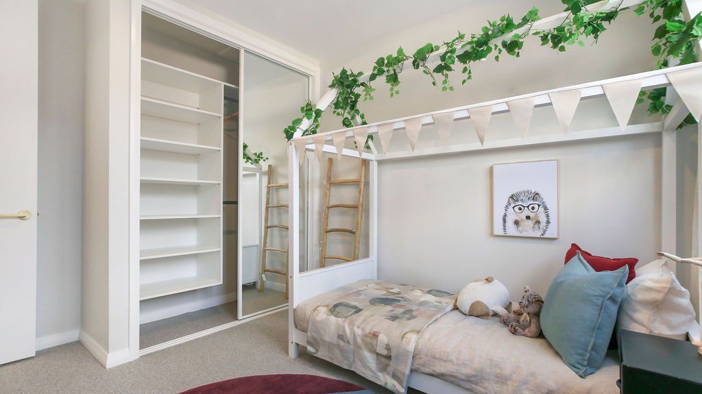 A bedroom with a canopy bed and a closet.