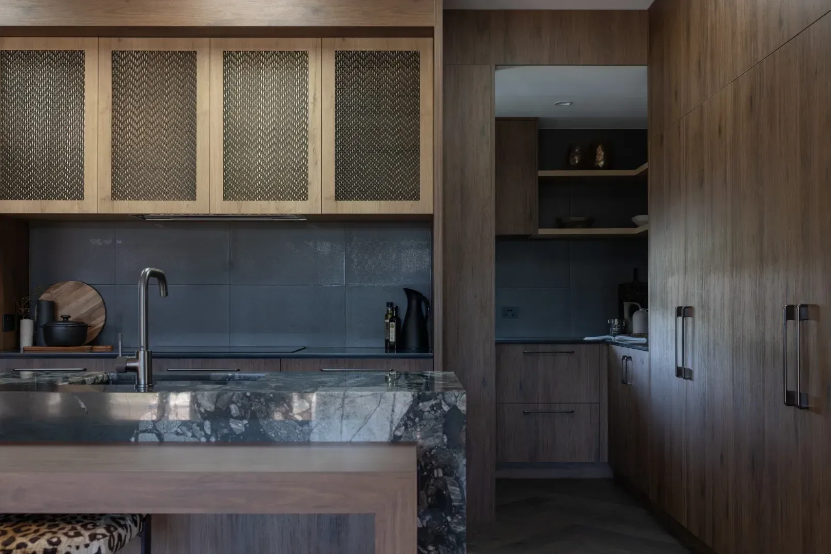 A kitchen with wooden cabinets and a marble counter top.