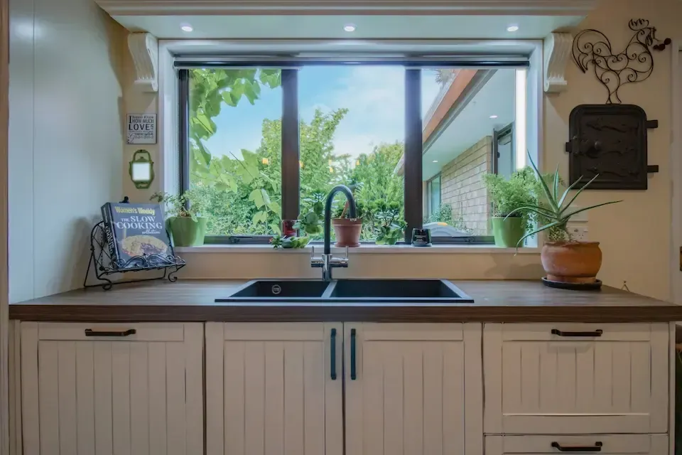 A kitchen with a sink and a large window