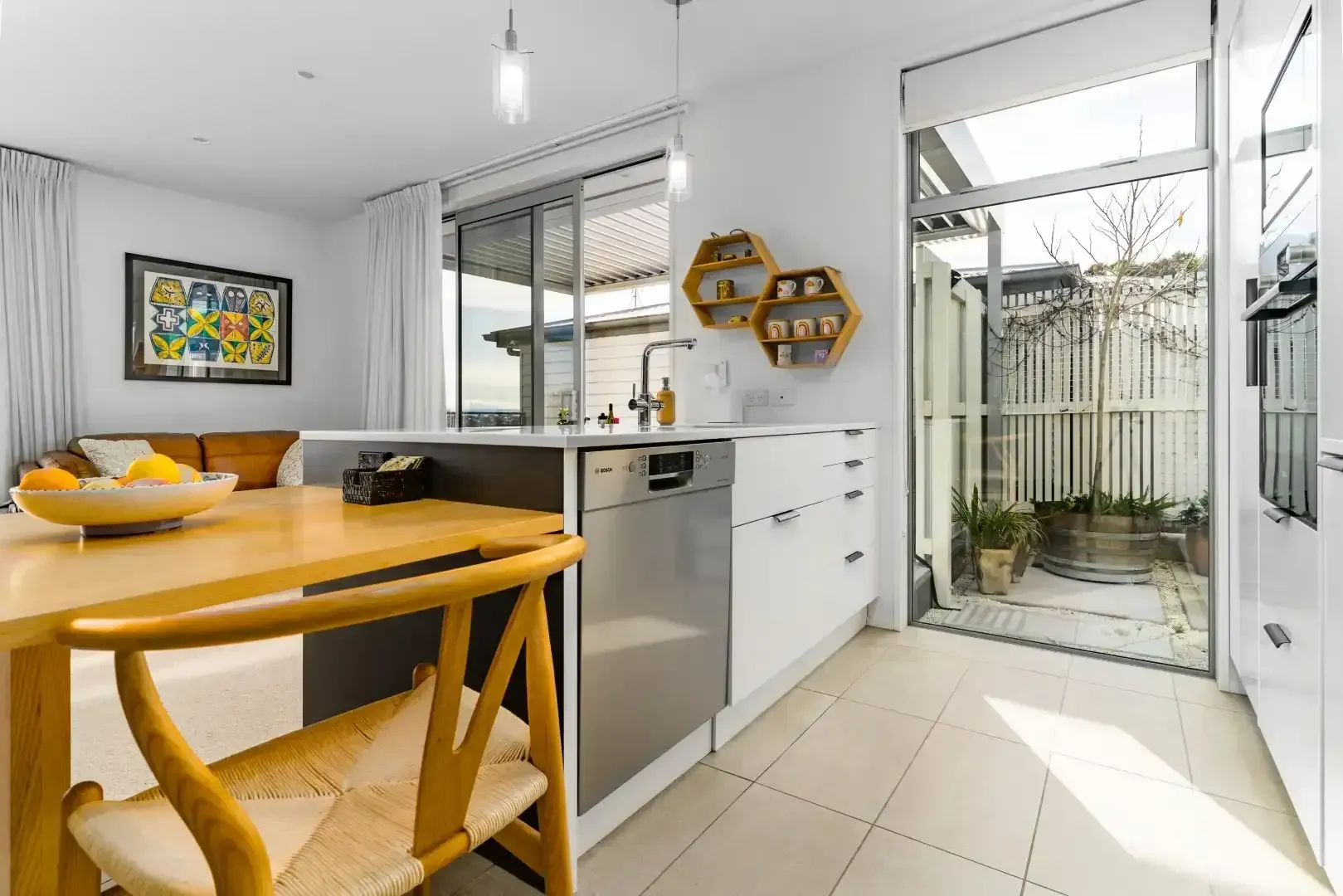 A kitchen with a table and chairs and a dishwasher.