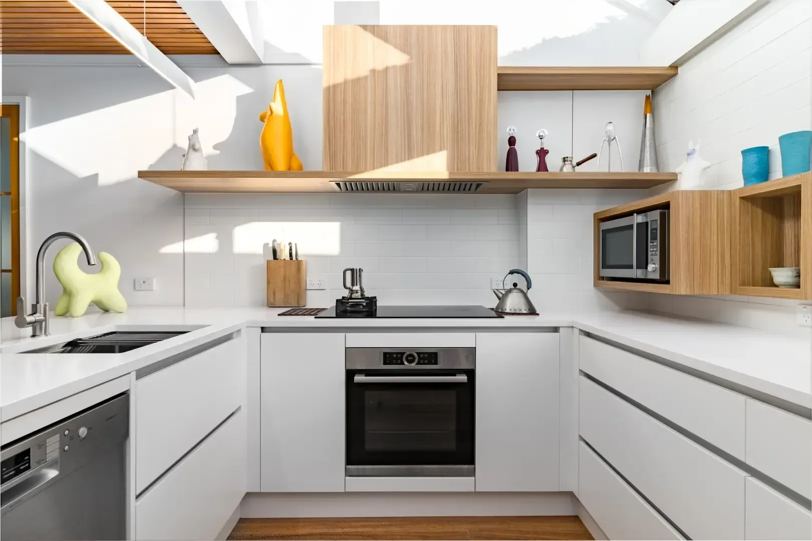 A kitchen with white cabinets , stainless steel appliances , and wooden shelves.