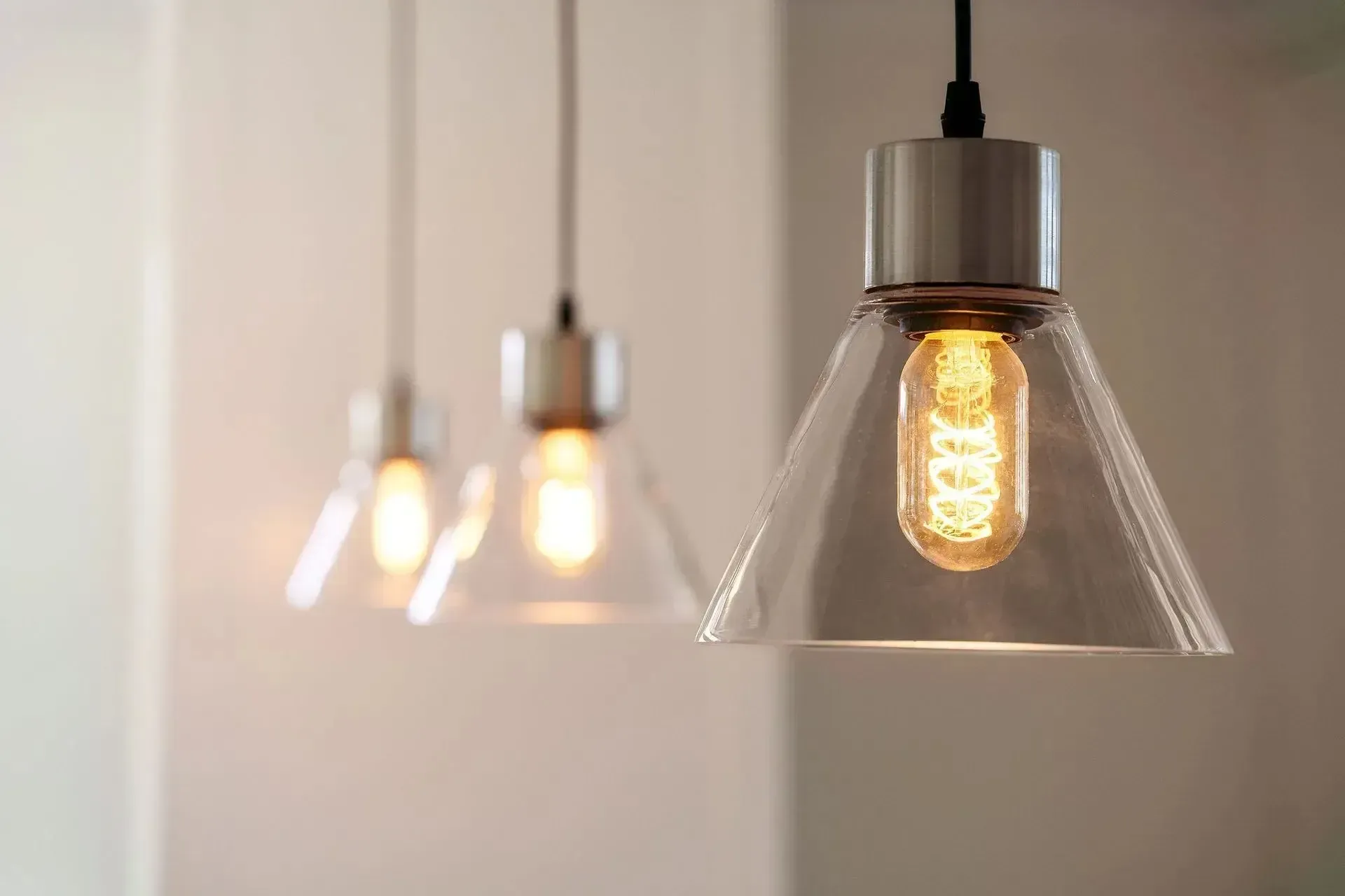 Three pendant lights with exposed Edison bulbs hang from ceiling.