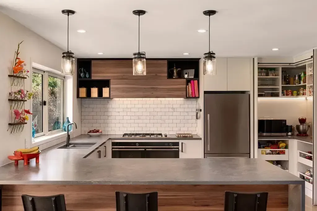 Modern kitchen with a large island, stainless steel appliances, and overhead pendant lights.