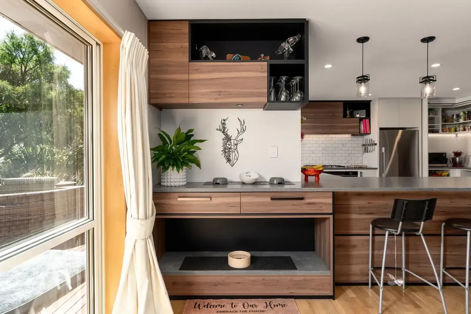 Modern kitchen with wooden cabinetry and a large window.