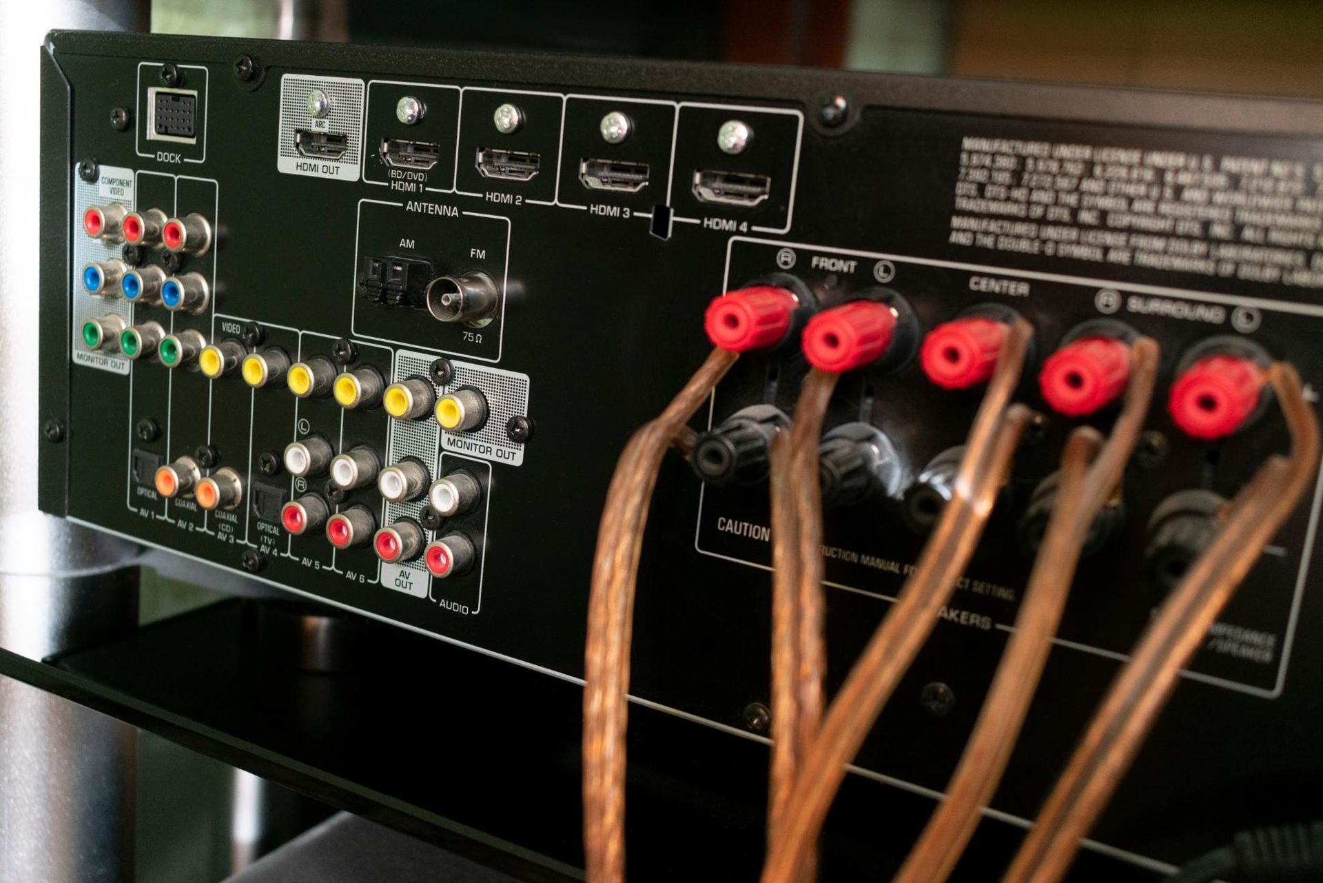 Back of an audio receiver with color-coded RCA jacks and connected cables