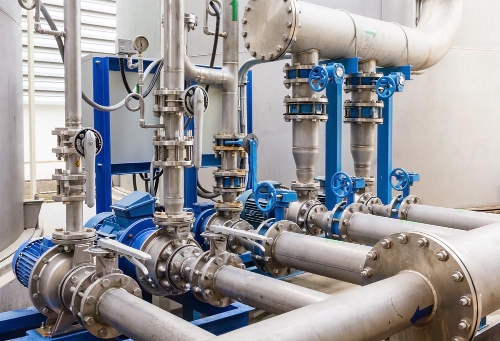 A Row Of Stainless Steel Pipes And Valves In A Factory — Accent Electrics In Noraville, NSW
