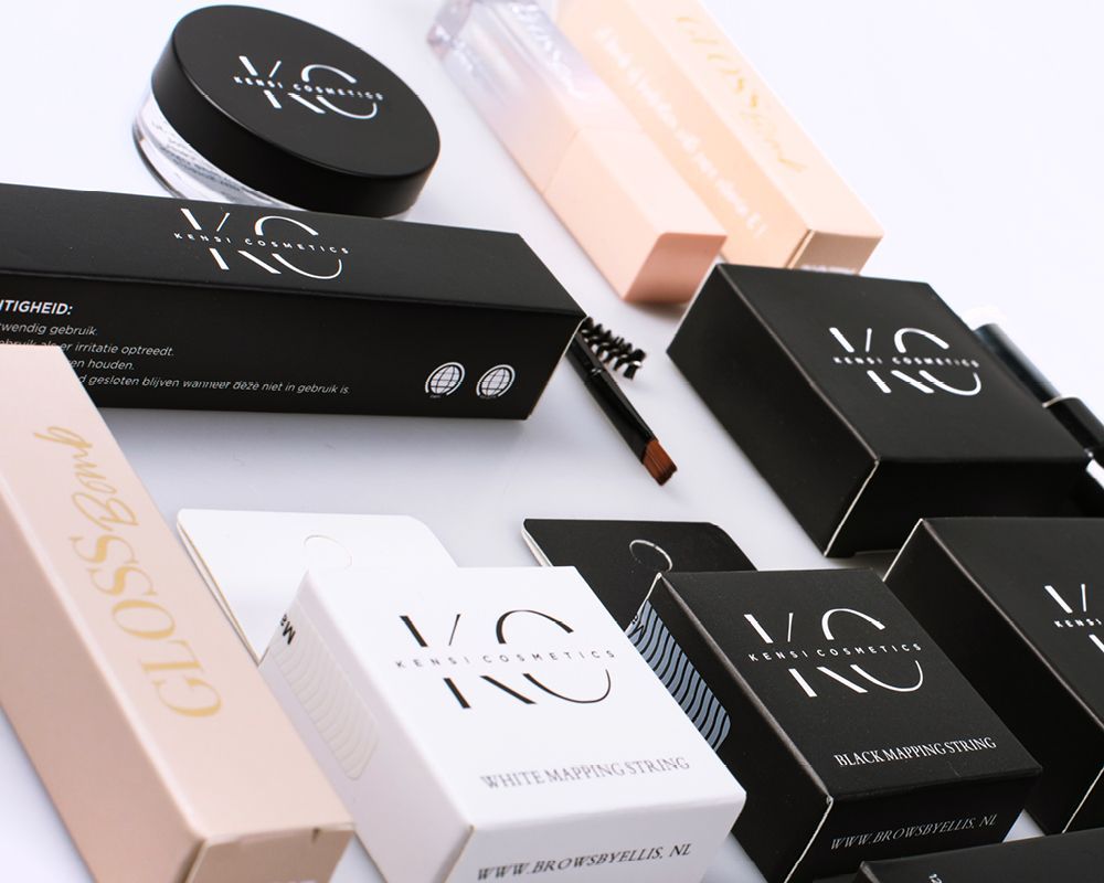 Cosmetische producten in zwarte, witte en beige dozen met het logo 