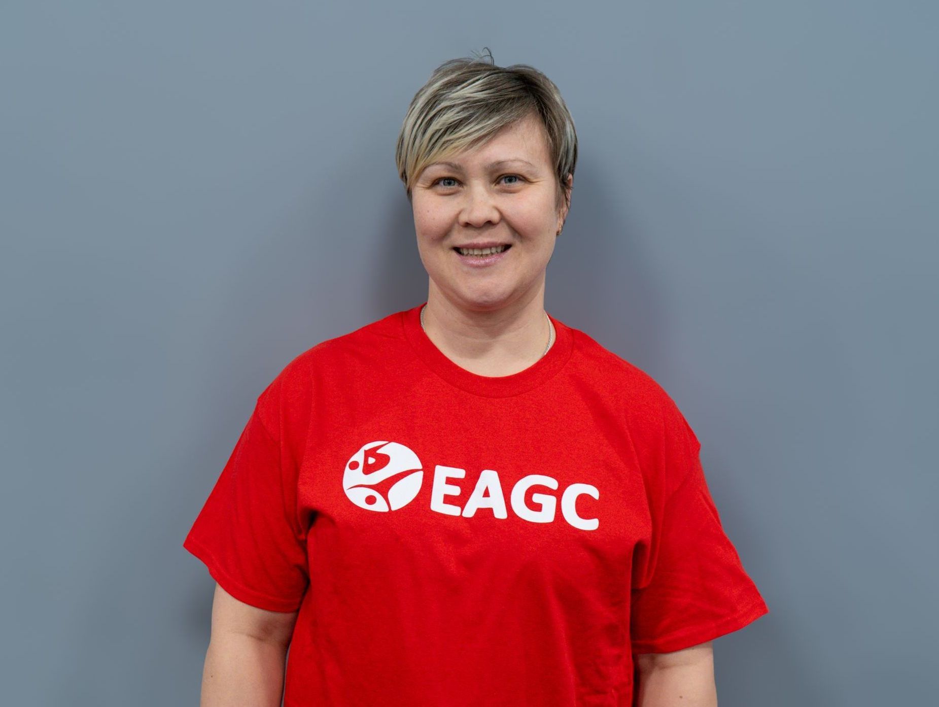A woman wearing a black t-shirt is smiling for the camera.