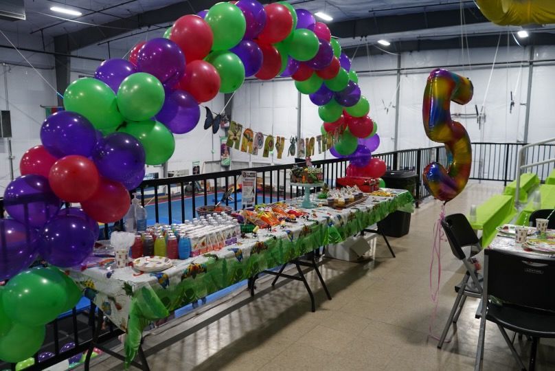 A table is decorated with a balloon arch.