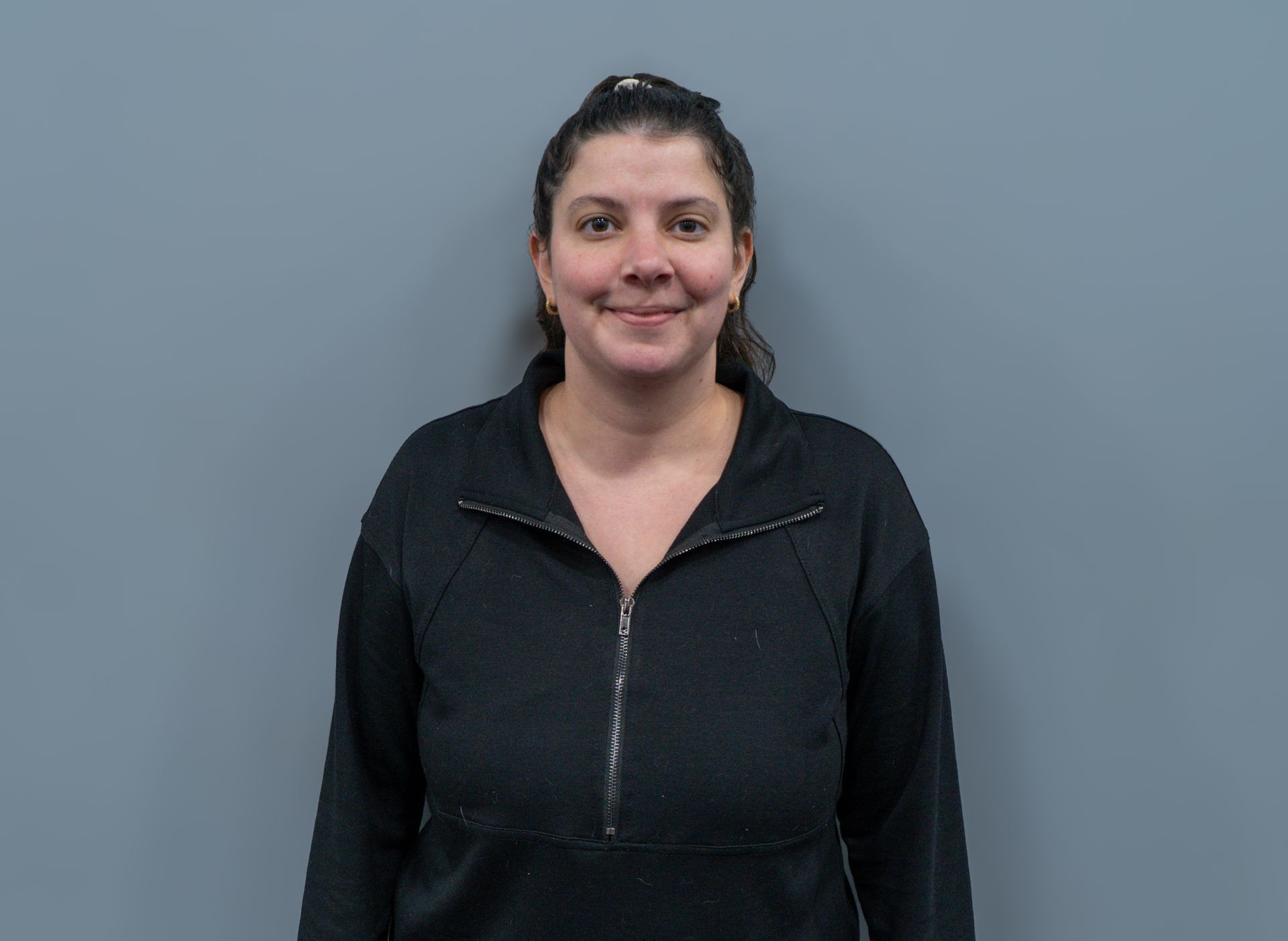 A woman in a black jacket is smiling for the camera.