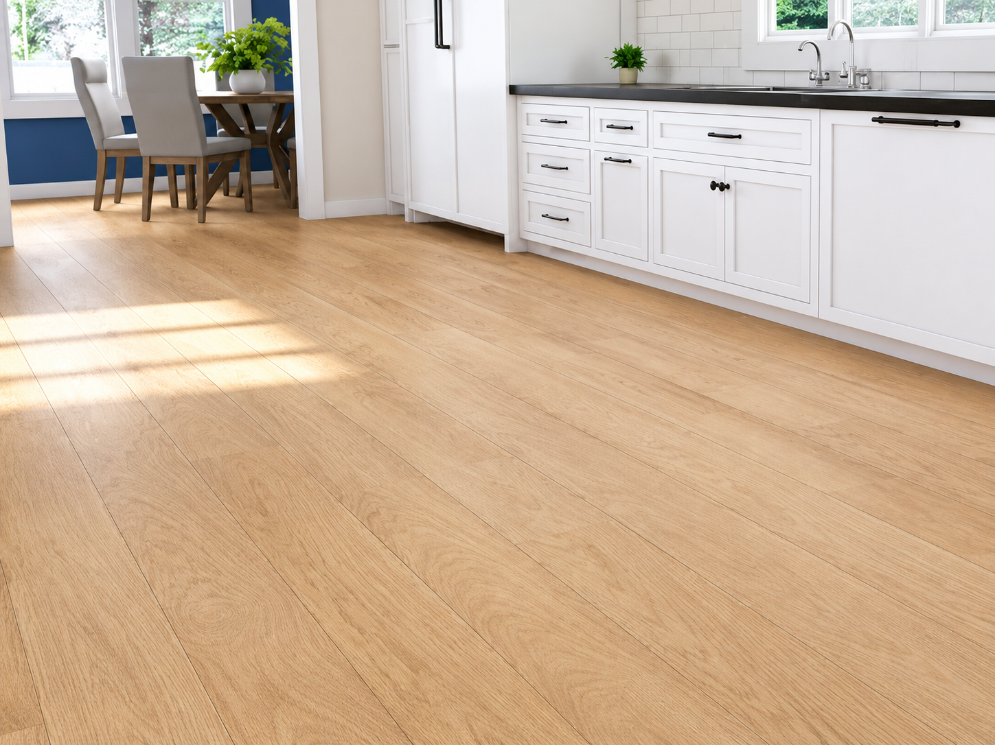 Bright empty kitchen with light wood flooring, white cabinets, and sunlight streaming in from a nearby dining area