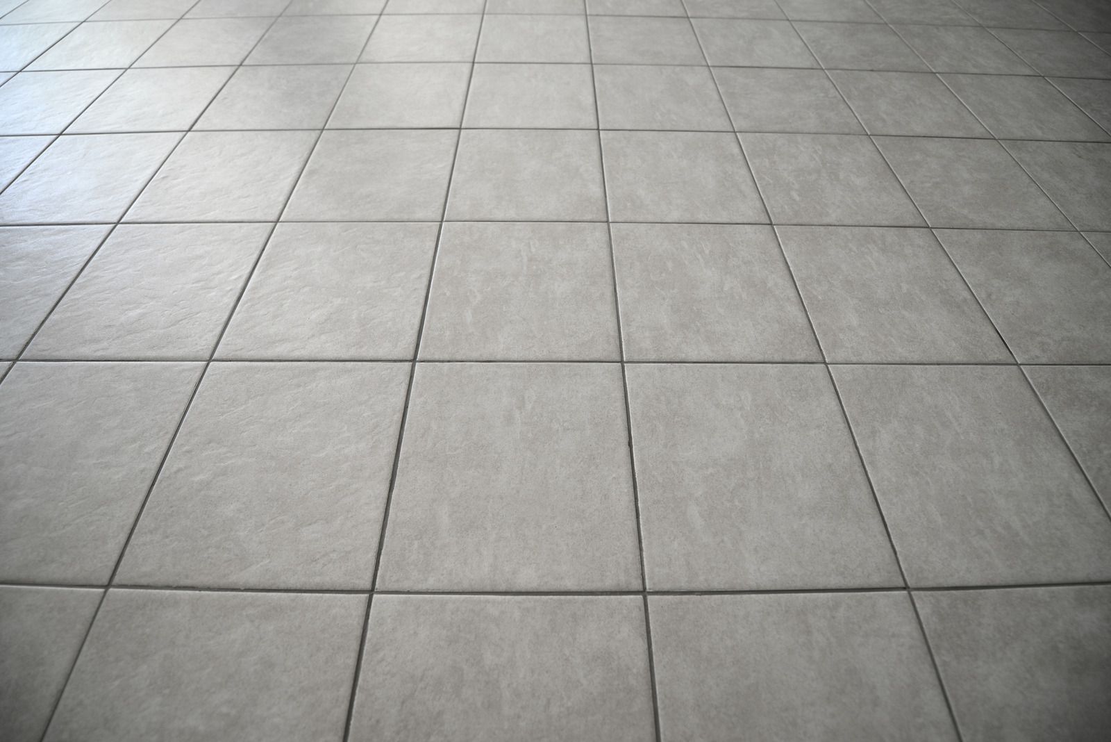 Gray tiled floor with a grid pattern, viewed from above.