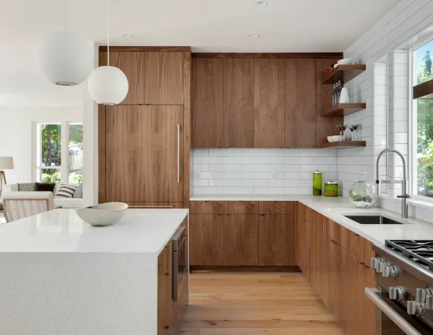 Bright modern kitchen with wood cabinets, white island, and large windows
