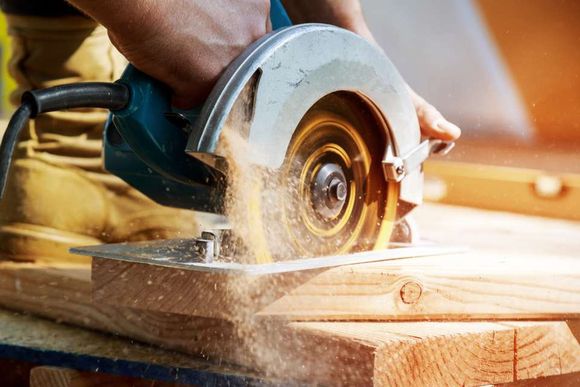 man cutting wood with the help of machine