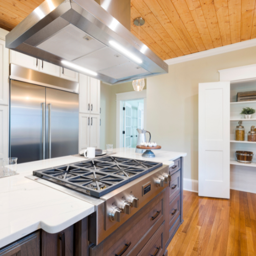A kitchen with a stove top oven and a refrigerator