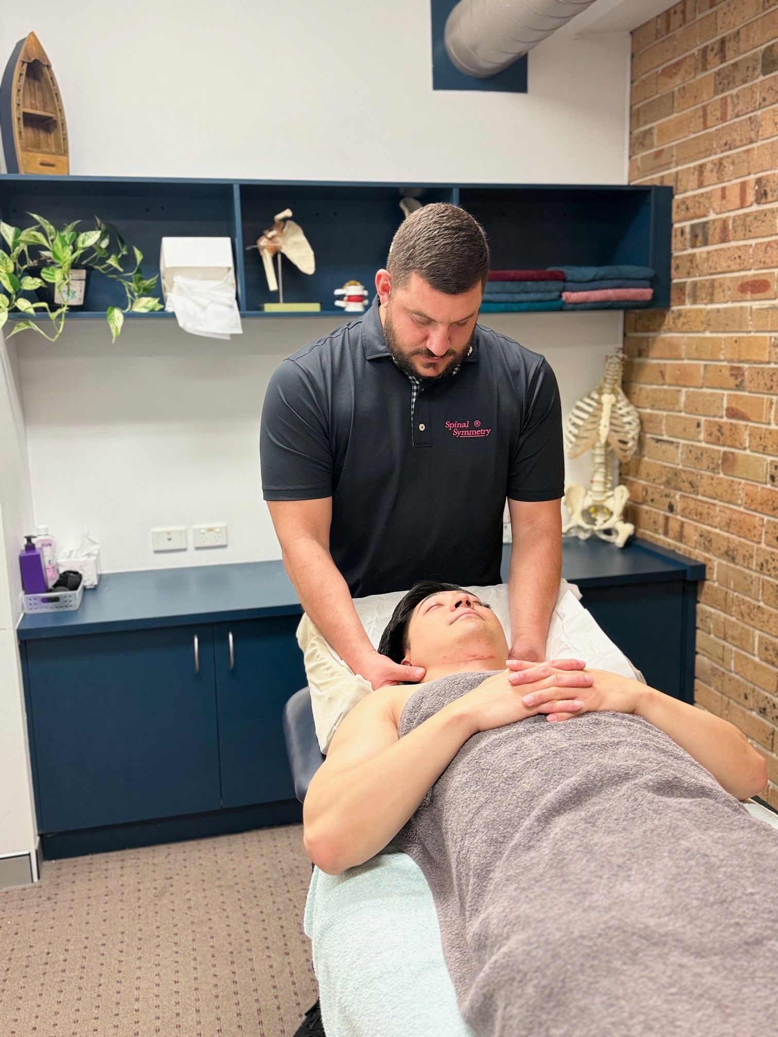 A Man Is Getting A Massage On his Neck — Spinal Symmetry In Salamander Bay, NSW