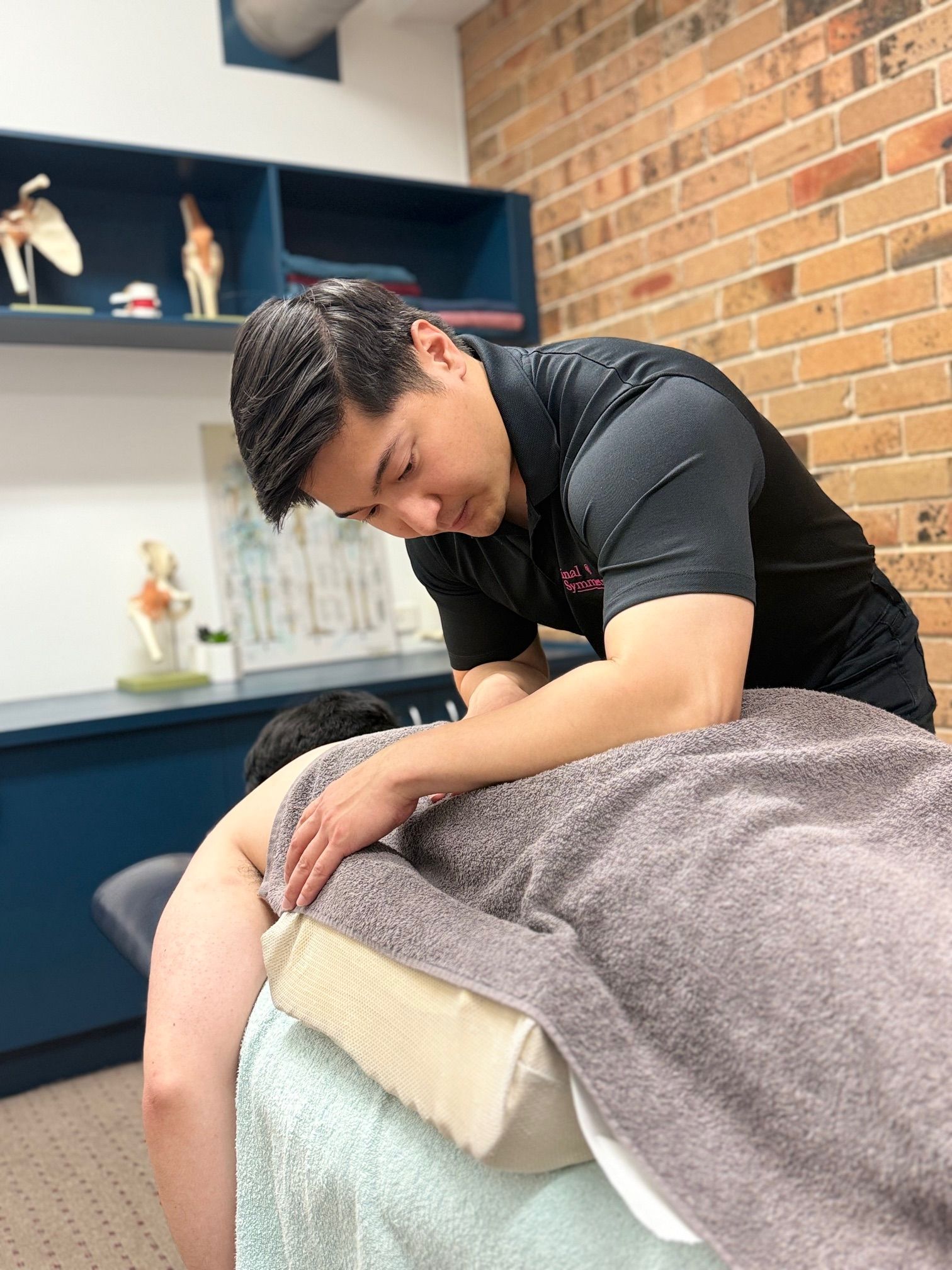 A Man Is Giving A Massage On A Bed — Spinal Symmetry In Salamander Bay, NSW