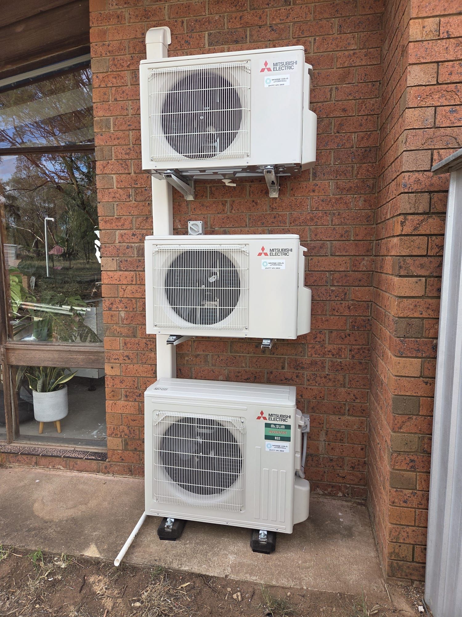 Wall-mounted white air conditioner on a light-colored interior wall. Wall-mounted white air conditioner on a light-colored interior wall.